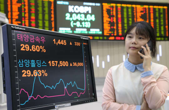 주식시장의 가격제한폭이 ±30%로 확대된 첫날인 15일 서울 여의도 한국거래소에서 한 직원이 가격제한폭인 30%까지 급등해 첫 상한가 진입 종목으로 기록된 태양금속우와 상한가에 가깝게 급등한 삼양홀딩스 주가를 지켜보고 있다. 사진= 김민수기자 ultratist@